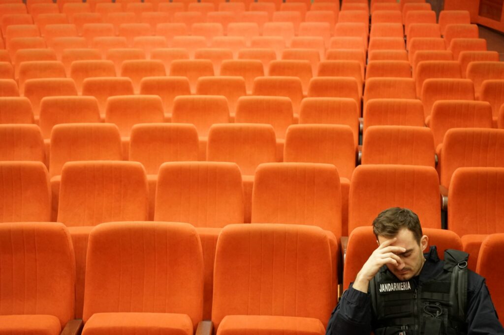 Conrad Mericoffer as Cristi sat in cinema in Poppy Field, a gay Romanian drama